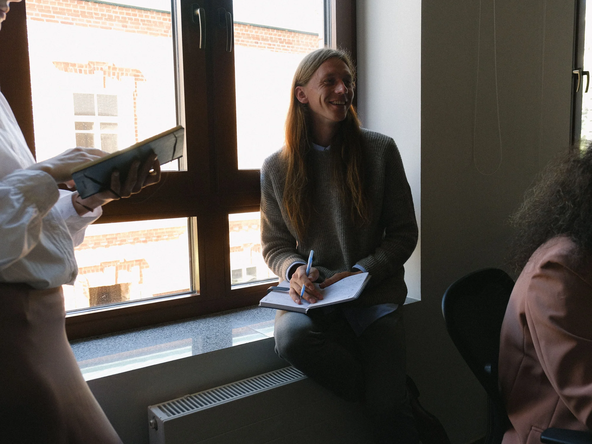 Colleagues talking by an office window